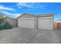 Two-car garage with gray exterior and paver driveway at 1793 N Westfall Ln, Casa Grande, AZ 85122