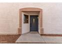 Gray front door with a sidelight window and small porch at 23957 W Tonto St, Buckeye, AZ 85326