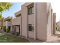 Side view of tan condo building showcasing windows and landscaping at 1920 W Lindner Ave # 147, Mesa, AZ 85202