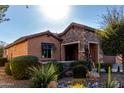 View of home's facade, showcasing stonework and drought-tolerant landscaping at 26653 W Firehawk Dr, Buckeye, AZ 85396