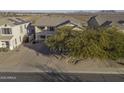Two story house with a three-car garage and a view of the surrounding neighborhood at 1340 E Kingman Pl, Casa Grande, AZ 85122