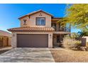 Two-story house with brown garage door and Spanish tile roof at 30384 N 128Th Ln, Peoria, AZ 85383