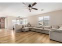 Spacious living room featuring an L-shaped sofa and wood floors at 43741 W Rio Grande Dr, Maricopa, AZ 85138