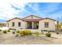 Light-colored stucco house with tile roof, attractive landscaping, and a porch at 562 N Sun Rd, Apache Junction, AZ 85119