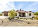 Tan house with brown roof, desert landscaping, and a paved driveway at 562 N Sun Rd, Apache Junction, AZ 85119