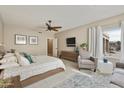 Spacious primary bedroom with a plush bed, sitting area and large window at 8689 E Windrose Dr, Scottsdale, AZ 85260
