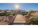 Brick walkway leads to a charming ranch home with a well-maintained lawn at 21391 E Orchard Ln, Queen Creek, AZ 85142