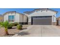 Single story home with a two-car garage and desert landscaping at 38124 W Santa Barbara Ave, Maricopa, AZ 85138
