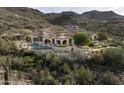 Luxury estate home nestled in the mountains with a large pool and landscaping at 11068 E Canyon Cross Way, Scottsdale, AZ 85255