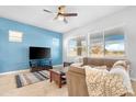 Spacious living room with a ceiling fan and large windows at 21576 E Pecan Ct, Queen Creek, AZ 85142