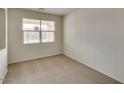 Bright bedroom featuring carpet flooring and a large window at 17625 W Sanna St, Waddell, AZ 85355