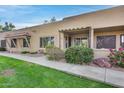 Tan stucco condo building with walkway, landscaping, and covered patio at 14300 W Bell Rd # 65, Surprise, AZ 85374