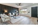 Modern living room with a dark accent wall, light furniture, and a large window at 3439 W Krall St, Phoenix, AZ 85017