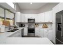 Modern kitchen with white cabinets, stainless steel appliances, and quartz countertops at 4636 E Danbury Rd, Phoenix, AZ 85032