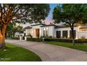 Elegant home with a curved driveway and lush landscaping at 5700 E Sanna St, Paradise Valley, AZ 85253