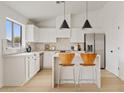 Modern white kitchen with stainless steel appliances and island at 8517 W Campbell Ave, Phoenix, AZ 85037