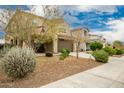 Two story house, light brown exterior, nicely landscaped front yard at 9567 W Robin Ln, Peoria, AZ 85383