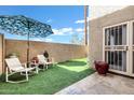 Small patio with artificial turf, chairs, and umbrella at 13610 S 41St Pl, Phoenix, AZ 85044