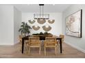 Modern dining room with wood table and statement wall decor at 17328 W Via Dona Rd, Surprise, AZ 85387