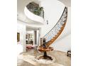 Impressive curved staircase with ornate railing and wood detailing at 19501 N 101St St, Scottsdale, AZ 85255