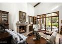 Spacious living room with fireplace, large windows, and access to backyard at 19501 N 101St St, Scottsdale, AZ 85255