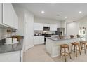 Modern kitchen with white cabinets, granite countertops and island at 35980 W San Ildefanso Ave, Maricopa, AZ 85138