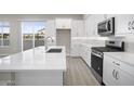 Modern kitchen with island, stainless steel appliances, and white cabinets at 4923 E Village Dr, Scottsdale, AZ 85254