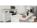 Modern kitchen with island, stainless steel appliances, and white cabinets at 18341 W Desert Hollow Dr, Wittmann, AZ 85361