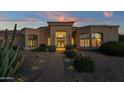 View of the home's exterior at dusk, highlighting the entryway and landscaping at 9325 E Paraiso Dr, Scottsdale, AZ 85255