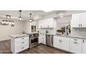 Modern kitchen with white cabinets, granite counters, and stainless steel appliances at 8039 E Madero Ave, Mesa, AZ 85209