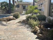 Inviting backyard with a sparkling pool, stone patio, and lush landscaping at 10100 N 78Th Pl, Scottsdale, AZ 85258