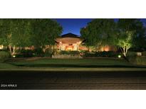 Elegant home exterior with manicured lawn and nighttime lighting at 15 Biltmore Estates Dr, Phoenix, AZ 85016
