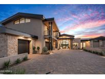 Modern home with stone and stucco exterior, large driveway, and landscaping at 38152 N 109Th St, Scottsdale, AZ 85262