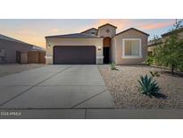 Tan two-car garage home with a landscaped front yard at 1137 E Viola Ct, Casa Grande, AZ 85122