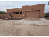 Spanish-style home with a two-car garage and desert landscaping at 25645 W Blue Sky Dr, Wittmann, AZ 85361