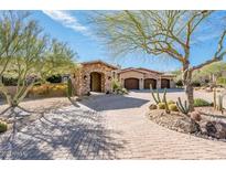 Luxury home with stone and stucco exterior, three-car garage, and landscaped courtyard at 29906 N Miradar Ct # 18&19, Scottsdale, AZ 85262