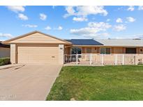 House exterior featuring a garage, solar panels, and landscaped yard at 10712 W Cameo Dr, Sun City, AZ 85351