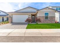 Modern Farmhouse style home with a stone facade and grassy lawn at 17227 W Middlebury St, Surprise, AZ 85388