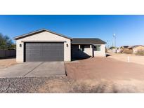 New single-story home with a gray exterior, attached garage, and a partially landscaped front yard at 4030 N Palm Cir, Eloy, AZ 85131