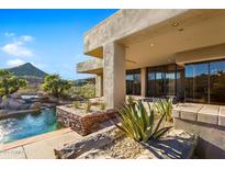 Luxury backyard oasis with a glistening pool, waterfall, and desert landscaping at 9917 E Filaree Ln, Scottsdale, AZ 85262