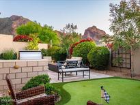 Landscaped backyard with putting green, fire pit, and built-in grill at 6296 N Lost Dutchman Dr, Paradise Valley, AZ 85253