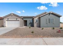 One-story home with gray siding, white garage door, and landscaped front yard at 37520 W Padilla St, Maricopa, AZ 85138