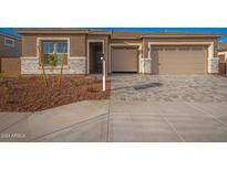 Front view of a two-car garage home with landscaped yard at 20230 W Hollyhock St, Buckeye, AZ 85396
