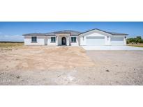 Single story home with two car garage and desert landscaping at 33618 W Encinas Ln, Tonopah, AZ 85354