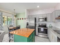 Modern kitchen with stainless steel appliances and butcher block island at 2146 W Harmont Dr, Phoenix, AZ 85021