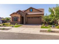 House exterior with landscaping and two-car garage at 23148 E Carriage Way, Queen Creek, AZ 85142