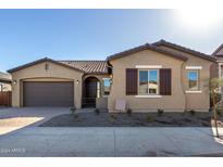 Exterior view of a single-story home with a two-car garage, stucco exterior, and landscaping at 21673 E Roundup Way, Queen Creek, AZ 85142