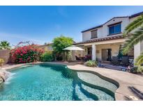 Inviting backyard oasis featuring a sparkling pool and waterfall at 14740 N 173Rd Ln, Surprise, AZ 85388