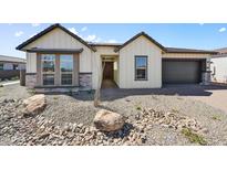 Cream-colored farmhouse style home with stone accents at 19003 W Lawrence Rd, Waddell, AZ 85355