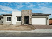 Modern two-car garage home with stone and neutral siding at 9808 S 37Th Dr, Laveen, AZ 85339